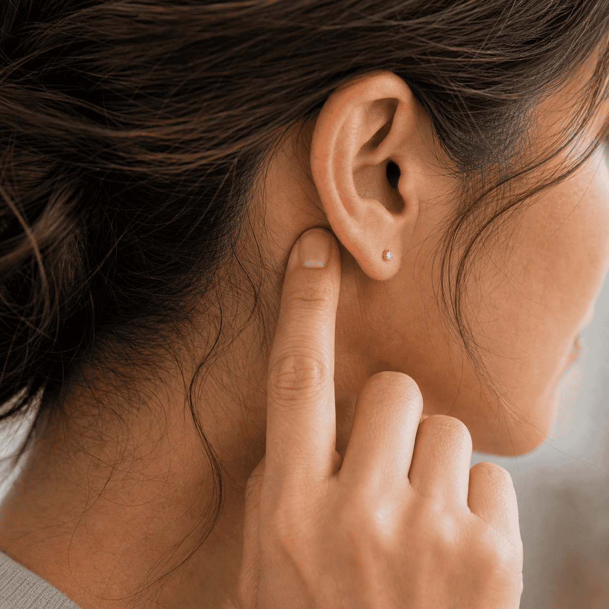 Self-care acupressure around the hollow behind the ear near the mastoid area
