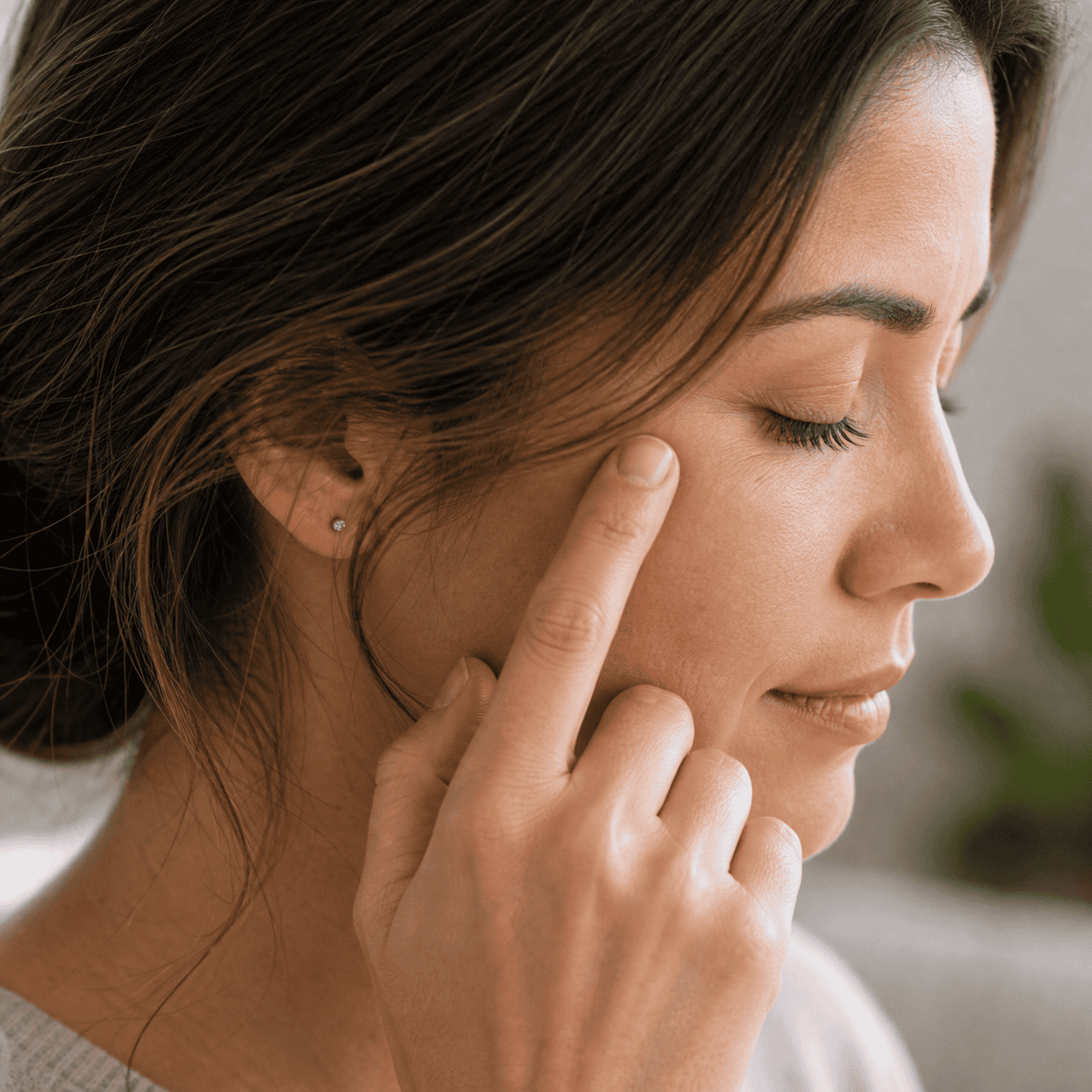 Self-care acupressure around the temple and cheekbone area above the zygomatic arch