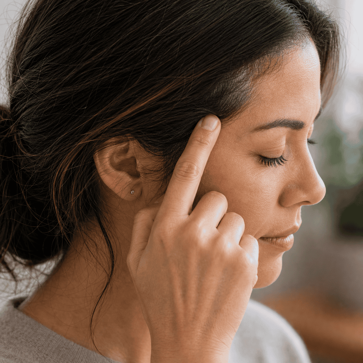 Self-care acupressure around the temple area within the hairline