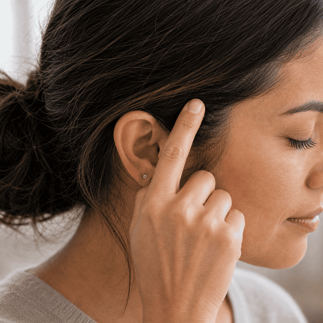Self-care acupressure around the side of the head above the ear